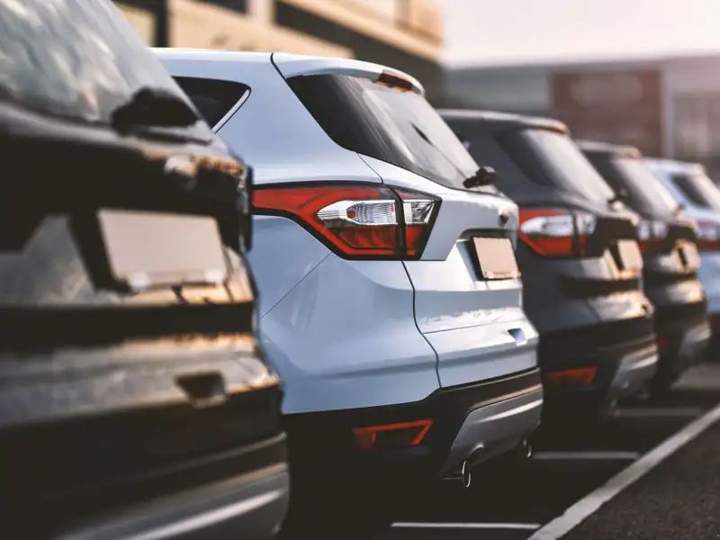 Cars parked in row on outdoor parking.