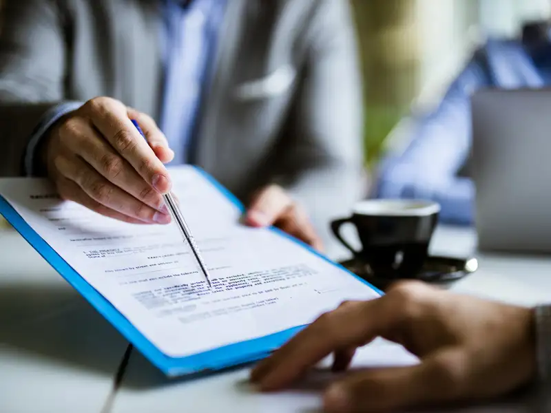 An agent points to the area of a contract to be signed.