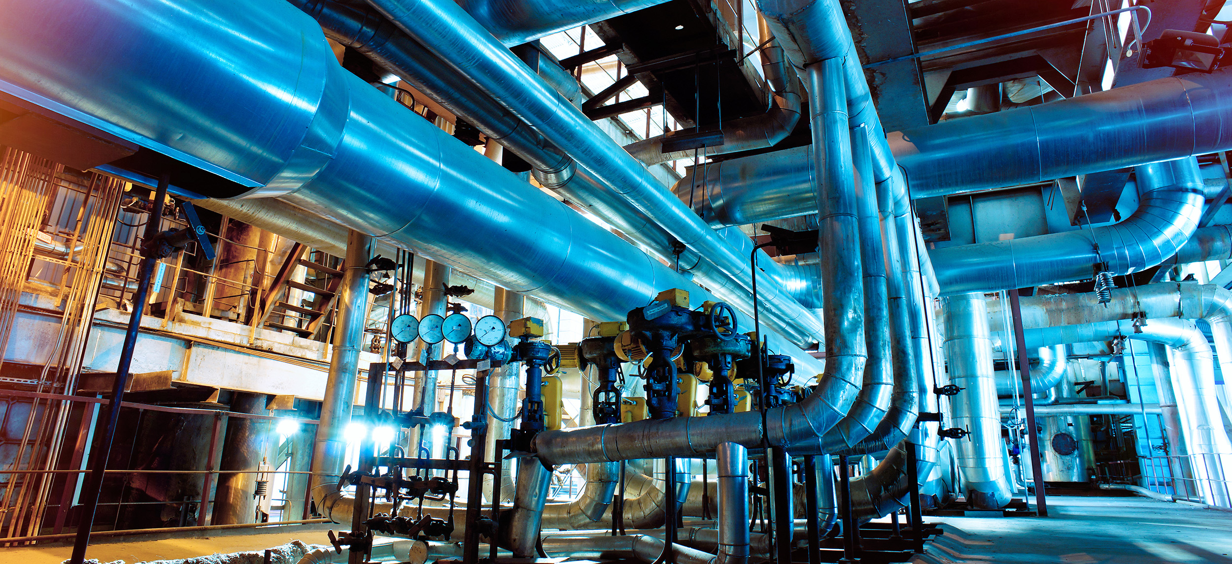 A heavy plant interior with large curving pipes.