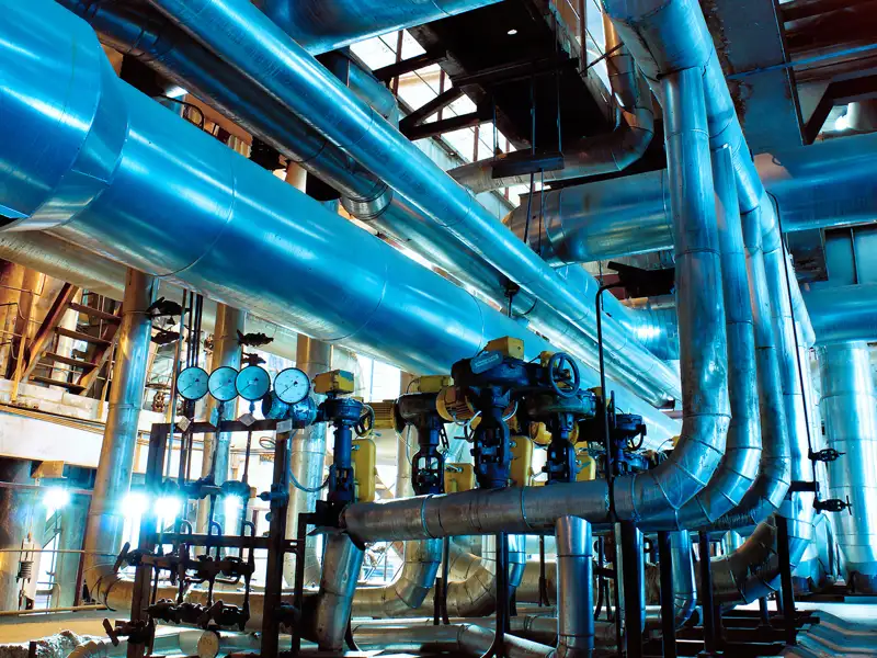 A heavy plant interior with large curving pipes.