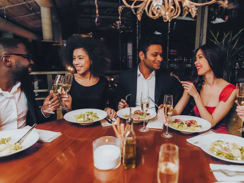 A group of friends enjoy a meal together at a nice restaurant.