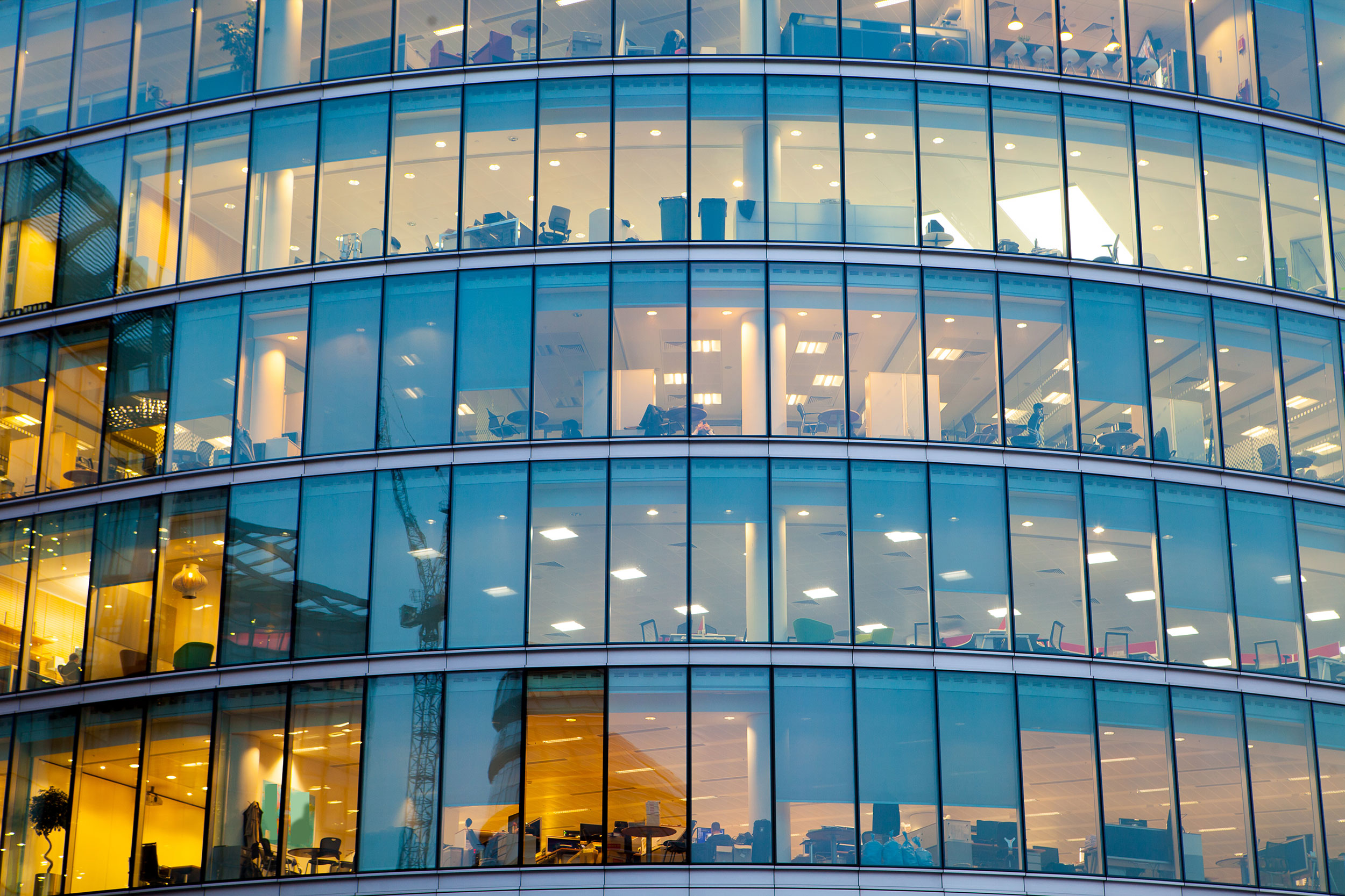 The glass windowed facade of a large office building.