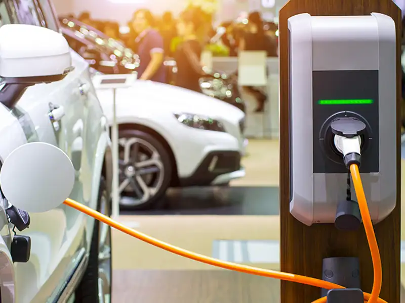An passenger electric vehicle refuels at a charging station.