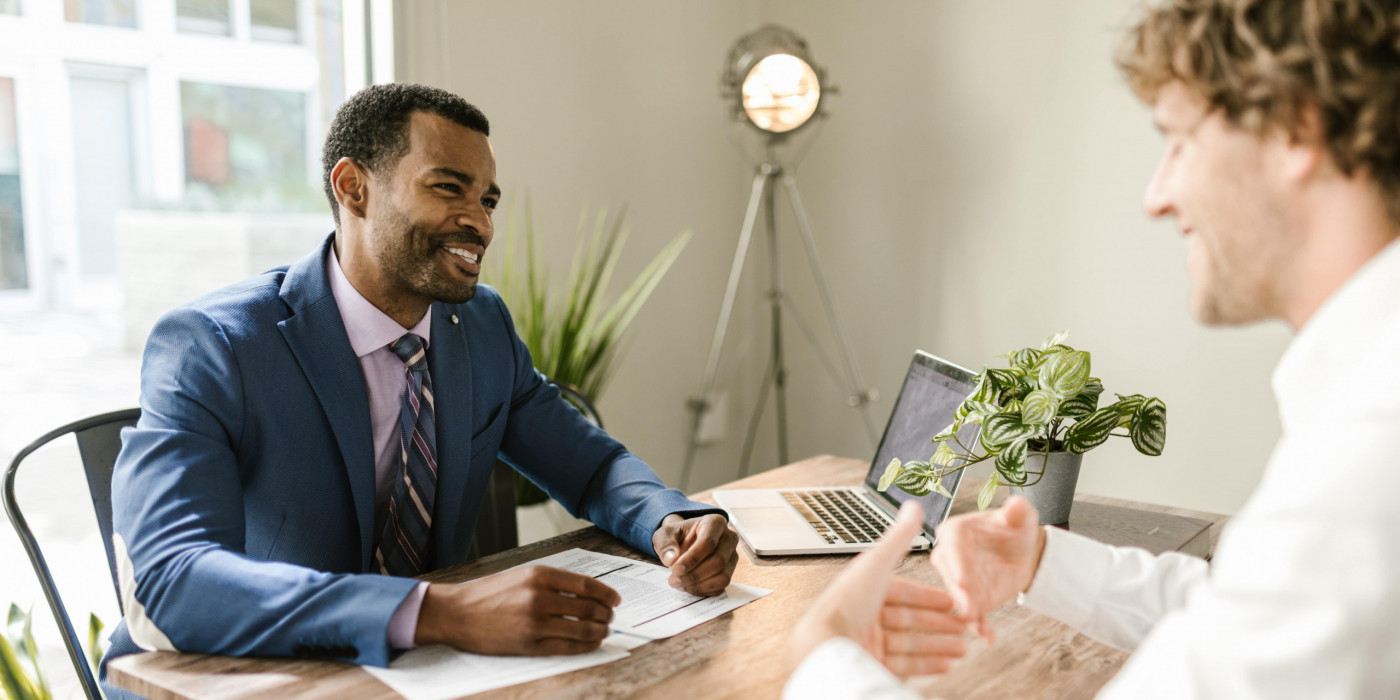 Business professional talking with a client in a modern office.
