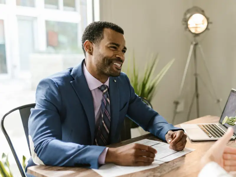 Business professional talking with a client in a modern office.