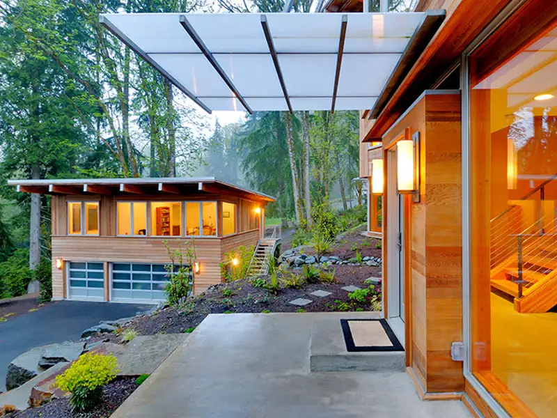 View from the patio of a modern house looking back toward its equally modern quest home.