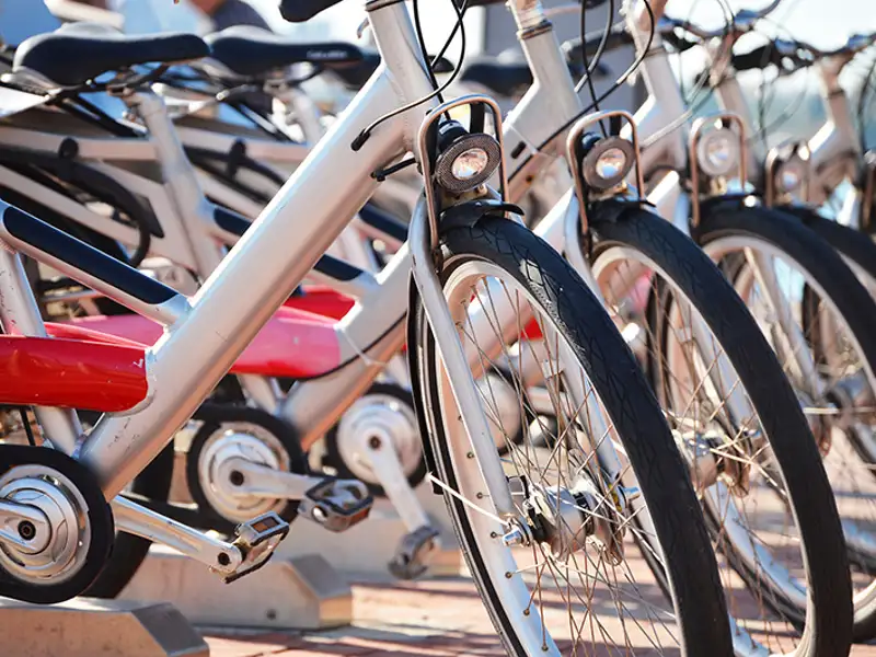 A line of white and red bicycles ready for public rental.