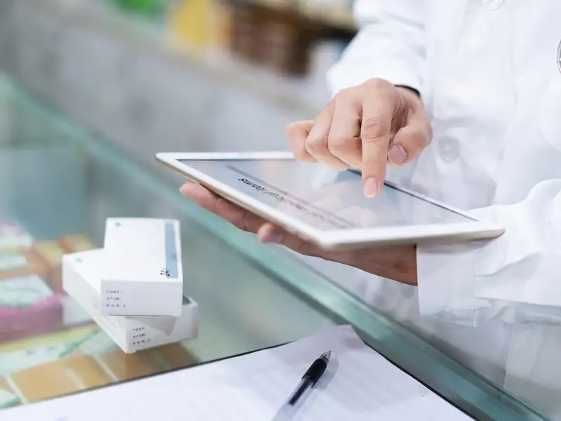 A clerk uses an electronic tablet during a counter transaction.