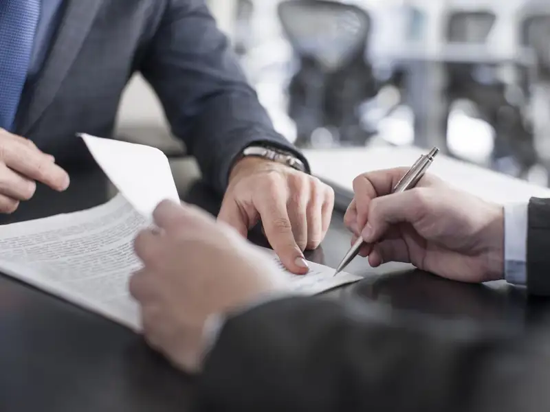 An agent points to the area of a contract to be signed.