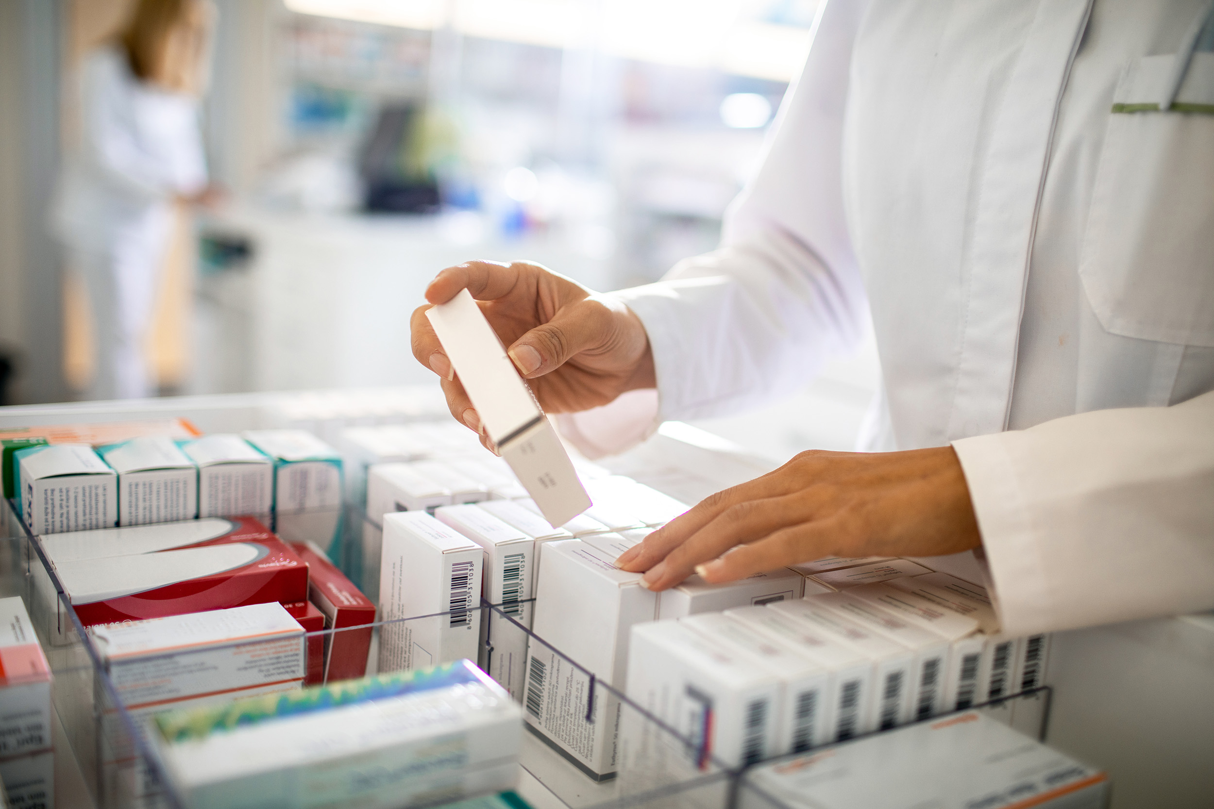A pharmacist selects a medication from a case.