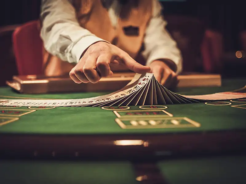 A casino dealer does a trick with a card deck.