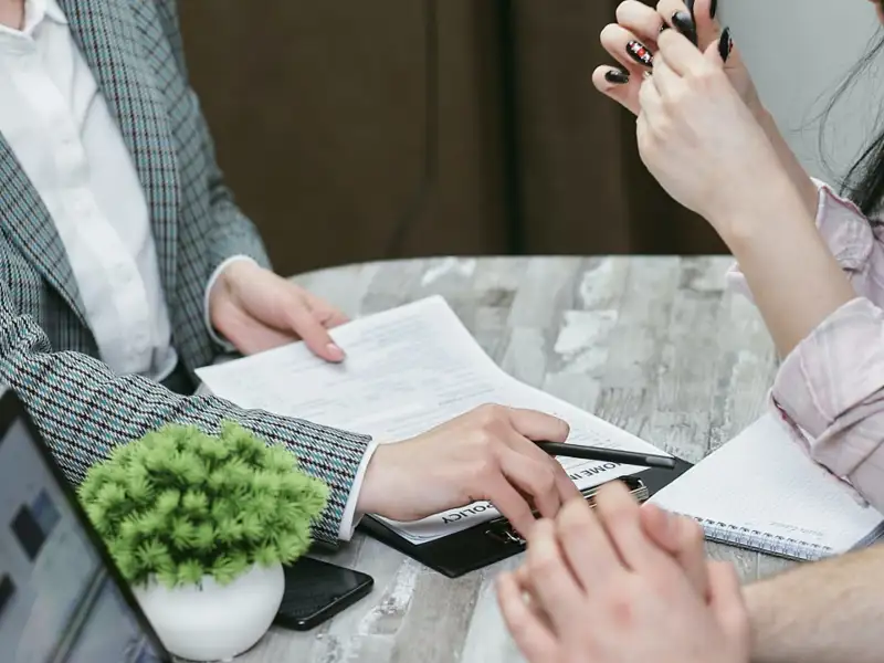 Female advisor pointing with a pen to notes on client paperwork.