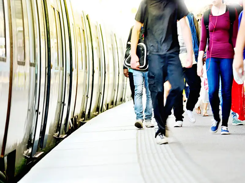 Train passengers walk along the platform.