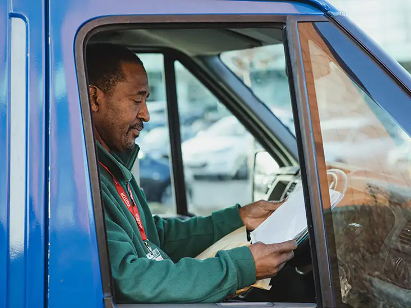 A professional driver reviews his sheet of delivery locations for the day.
