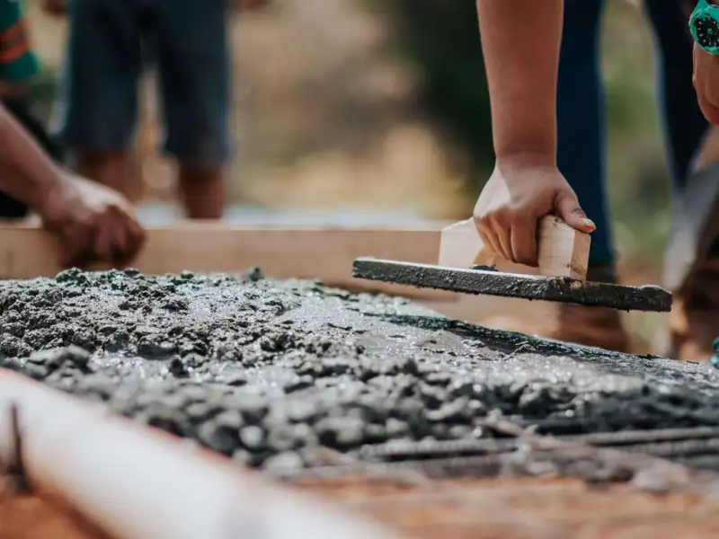 Construction workers laying concrete for a new house build.