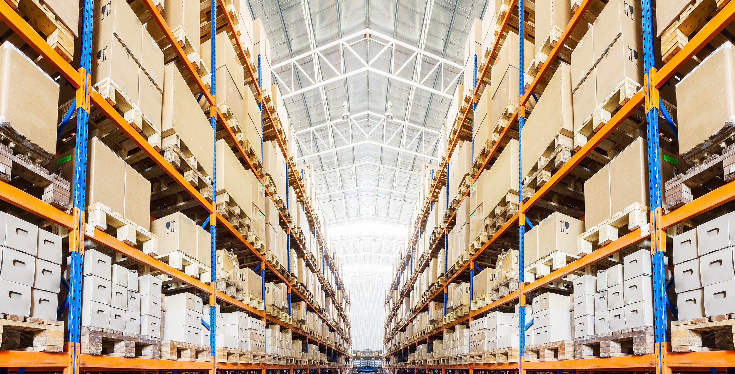 Shelves of boxes stacked high in a large warehouse.