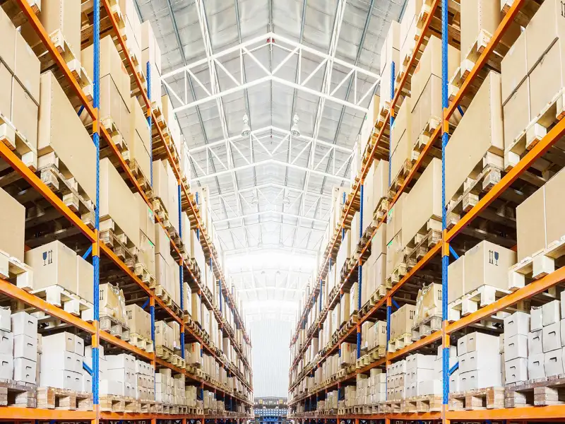 Shelves of boxes stacked high in a large warehouse.