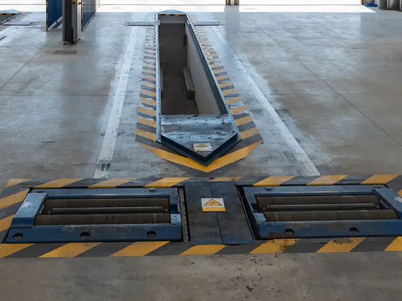 An inspection pit ready for use in a vehicle inspection shop.