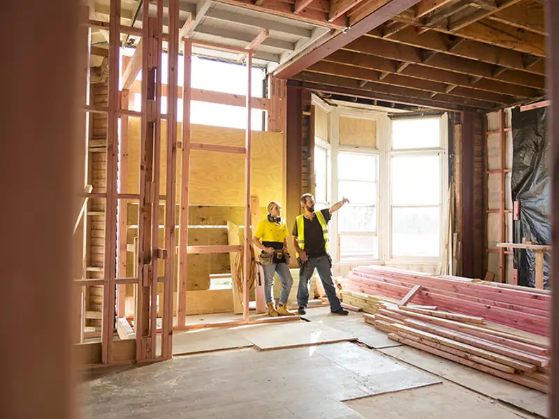 Two carpenters do a walkthrough of a framed structure.