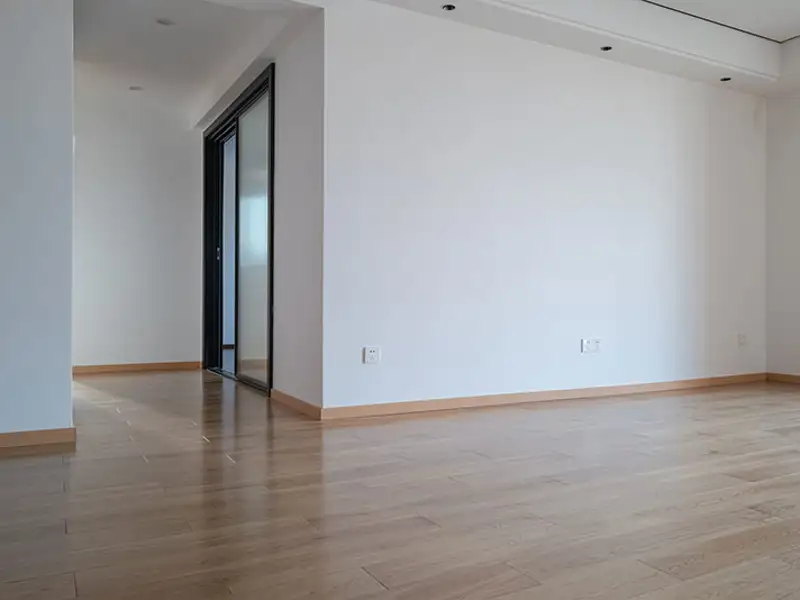 The open expanse of a wood-floored living space in an unoccupied home.