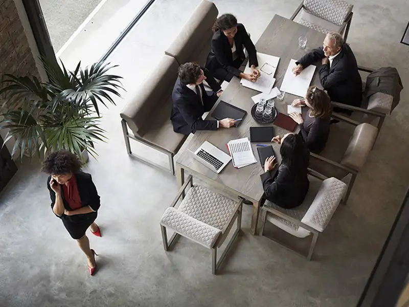 An overhead view of business professionals working together at a small conference table.