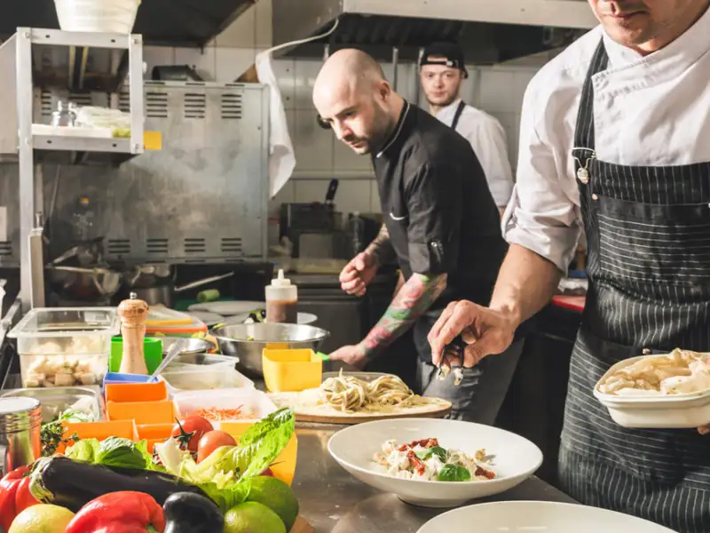 Chefs cooking in a busy commerical kitchen.