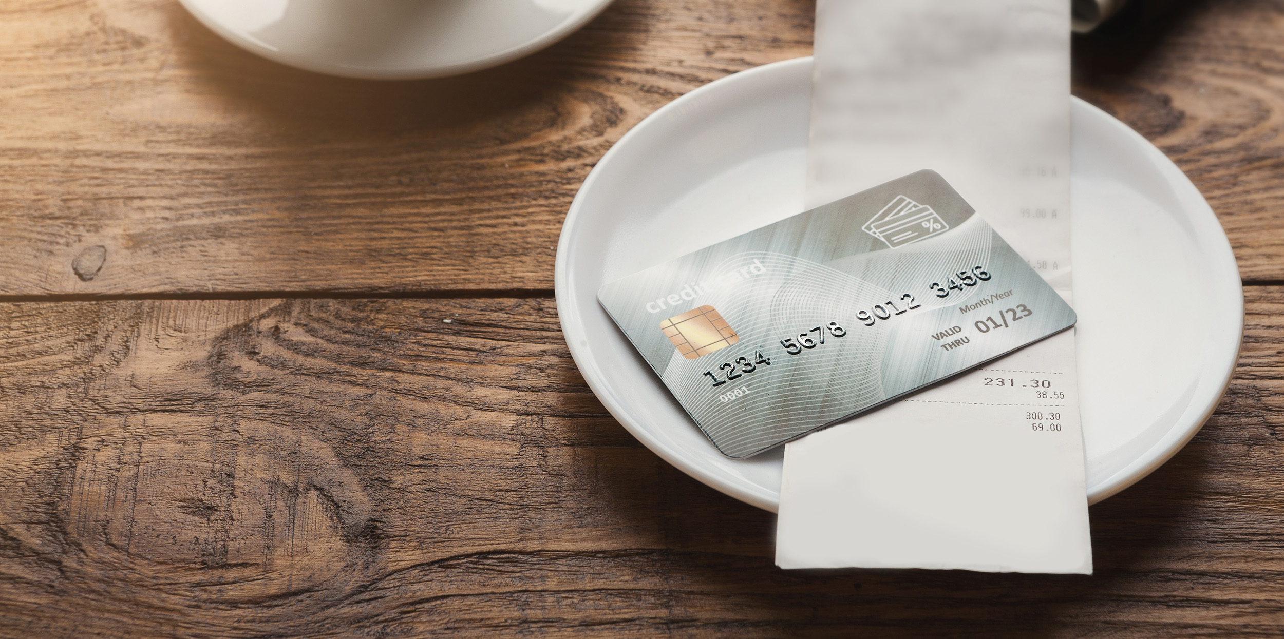 A credit card sits on a restaurant table awaiting pickup by waitstaff.