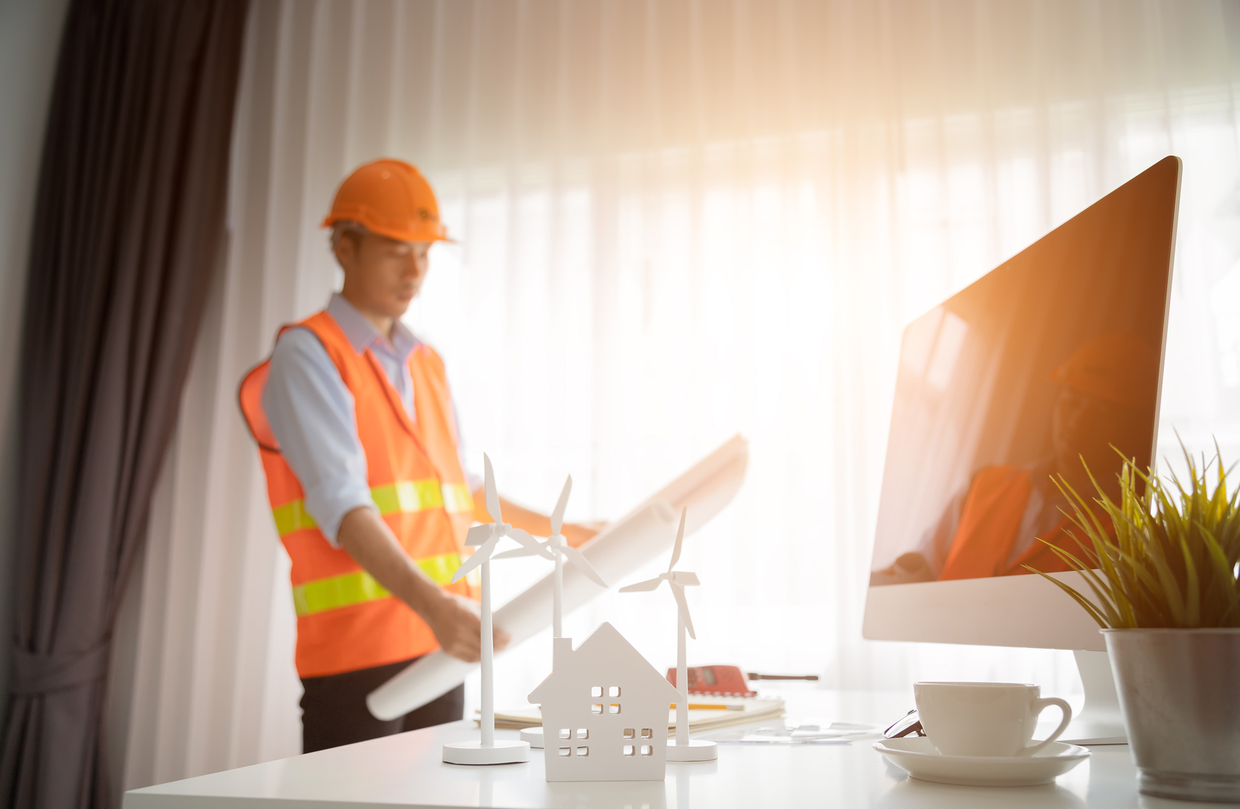 A contractor studies site plans in an office.