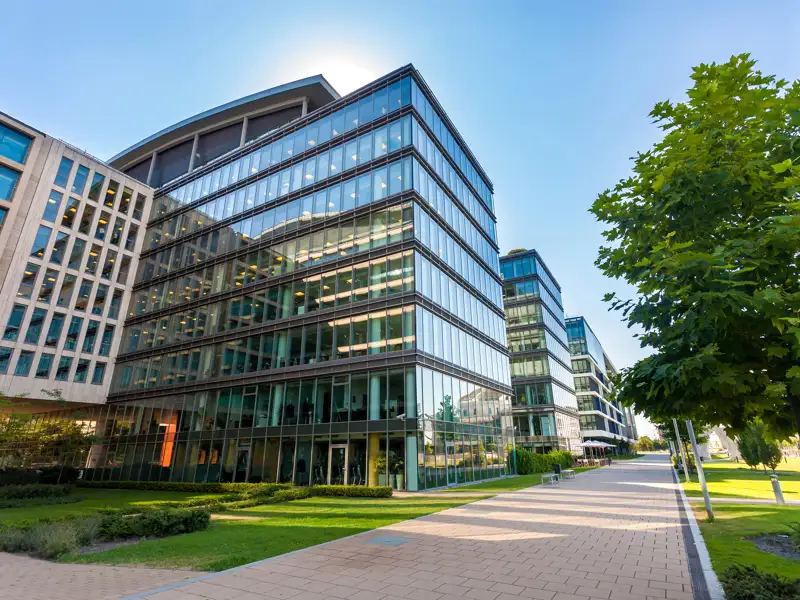 A row of glass buildings along a path in a business centre.