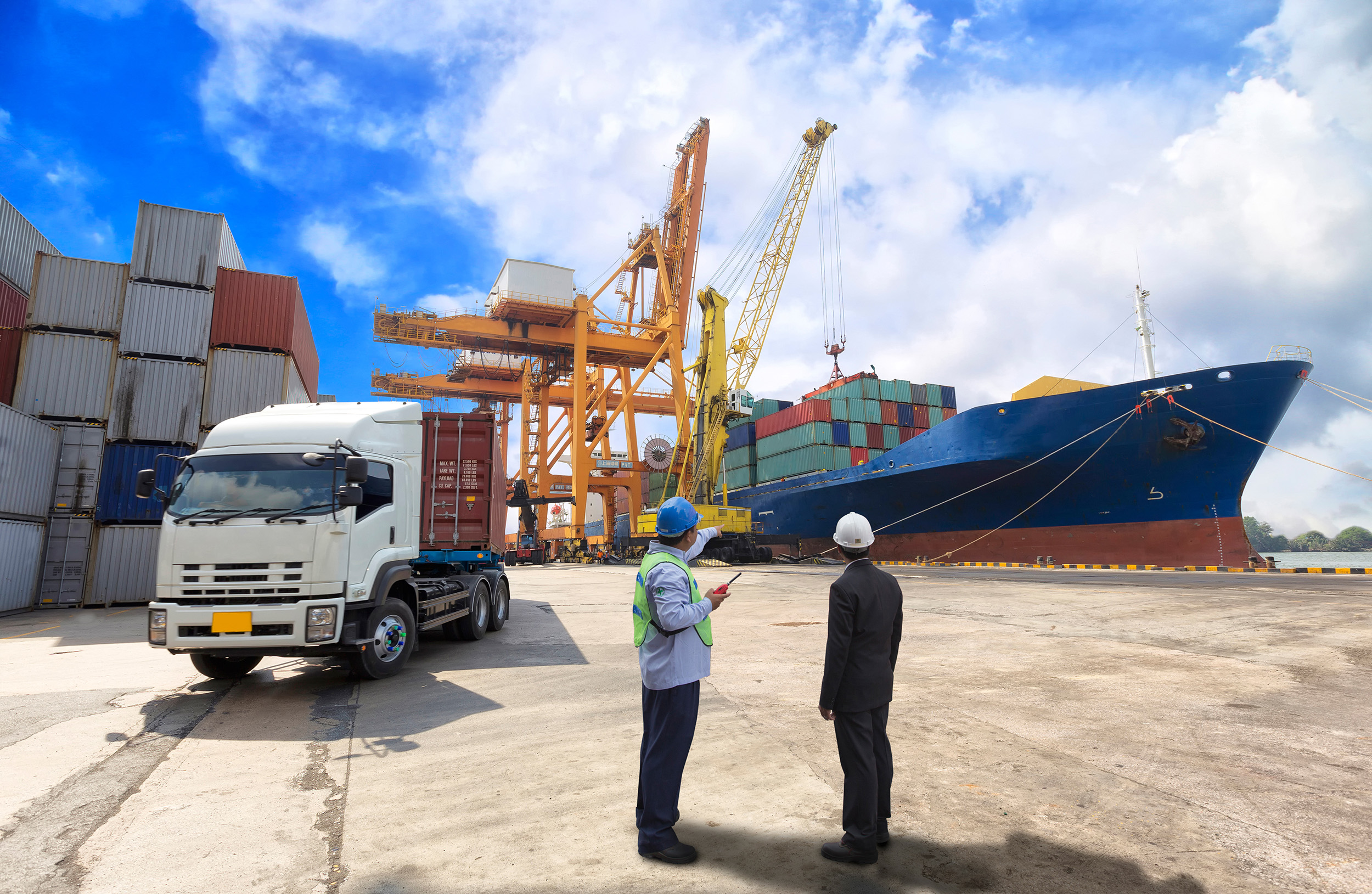 Dock workers discuss the offloading of a large ship.