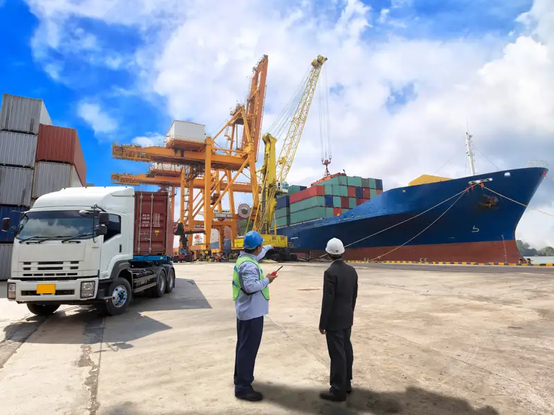 Dock workers discuss the offloading of a large ship.