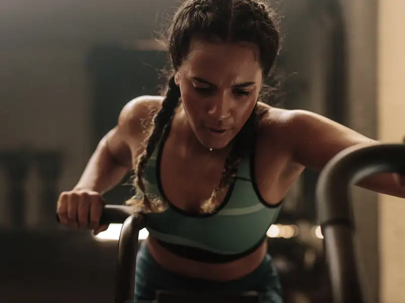 A woman works out on a piece of exercise equipment.